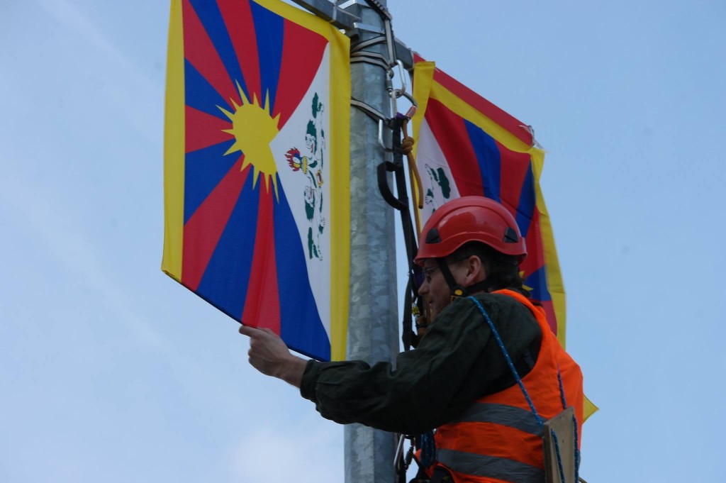Jan Rovenský vyvěšuje tibetskou vlajku na Evropské třídě