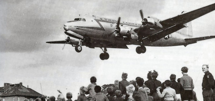 Obyvatelé Berlína sledují letoun Douglas C-54 Skymaster operující v rámci leteckého mostu do jejich města